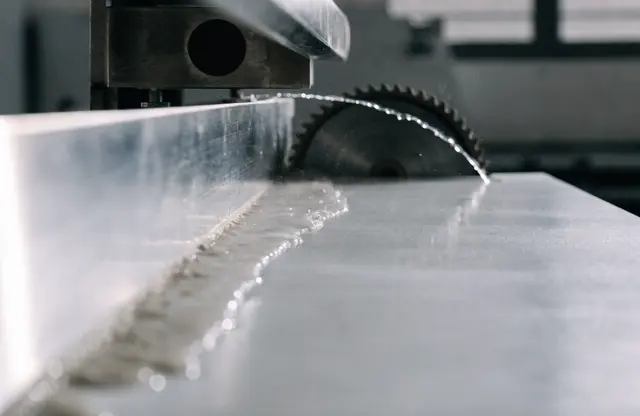 Visualisierung eines Nassschnitts: ein Sägeblatt schneidet eine grossformatige Platte, ein Wasserfilm läuft über die Schnittkante.